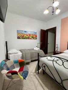 圣塔马里亚迪卡斯特a casa di Ale的一间设有两张床、椅子和绘画的房间
