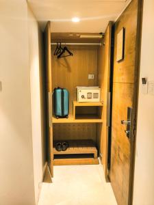 孟买拉米客人线卡尔酒店的一间小客房,设有一间配有微波炉的厨房
