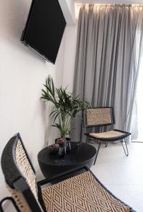 达拉索Nuovo Luxury Suites的客厅配有桌椅和电视。