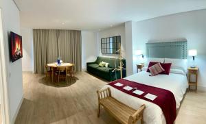 奇皮奥纳Apartamentos Turísticos La Plaza的酒店客房设有一张大床和一张绿色沙发。