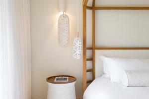 伊罗达Phāea Blue Palace的一间卧室配有一张床和两个吊灯