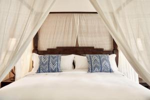 伊罗达Phāea Blue Palace的一间卧室配有一张带蓝色和白色枕头的床