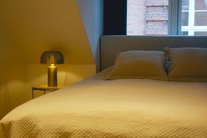 科灵STAY Penthouse的一间卧室配有一张带灯和窗户的床