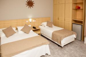 迪维诺波利斯River Palace Hotel的酒店客房配有两张床和一张书桌