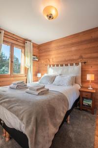 莫尔济讷Beautiful 2 bed Chalet Morzine的一间卧室配有一张带木墙的大床