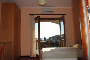 桑吉内托拉瑞斯酒店的一间卧室设有通往阳台的开放式门