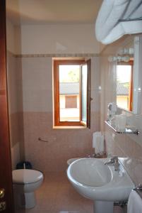 桑吉内托拉瑞斯酒店的一间带水槽和卫生间的浴室以及窗户。