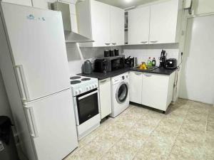 伦敦Apartment - Heart of London!的厨房配有冰箱和洗衣机。