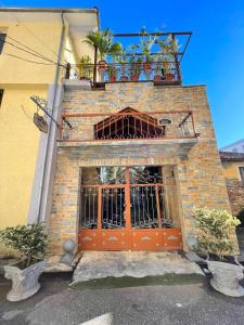 斯库台Shkodra Guest House的一座砖砌建筑,设有橙色的门和阳台