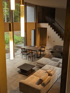 富士河口湖ASH Villa Fujikawaguchiko的带沙发和桌子的客厅以及楼梯