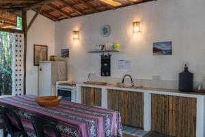 Praia dos AlgodõesGlamping Coco Dendê - Algodões的厨房配有带水槽的柜台和冰箱。