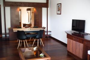 Maharepa莫雷阿摩纳海滩度假酒店的客厅配有桌椅和电视。