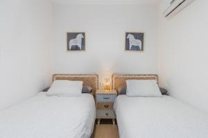 马拉加Nosquera FreshApartaments by Bossh! Apartaments的卧室设有两张单人床和床头柜