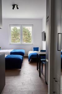 华沙Top Loft Znana的客房设有两张床、一张桌子和一扇窗户。