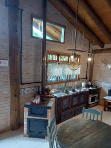 伊比拉奎拉Pousada Bosque das Águas, Imbituba的厨房配有桌子、水槽和炉灶。