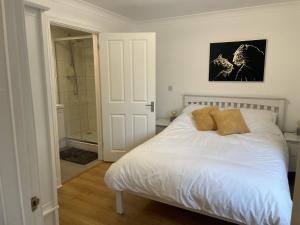 贝里圣埃德蒙兹Modern The Mews Apartment的卧室配有白色的床和淋浴
