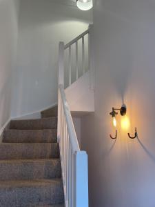 贝里圣埃德蒙兹Modern The Mews Apartment的白色墙壁和光线的楼梯