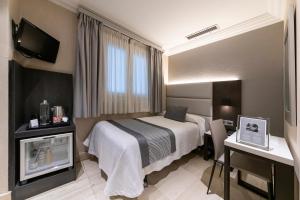 潘普洛纳Hotel Europa的配有一张床和一张书桌的酒店客房