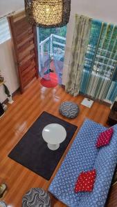 DaetCozy TinyHouse near SM City Daet的客厅铺有木地板,配有2张垫子