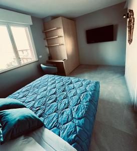 弗利OliVia Rooms Sauna & Gym的一间卧室配有蓝色的床和电视
