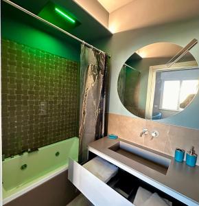 弗利OliVia Rooms Sauna & Gym的带浴缸、水槽和镜子的浴室