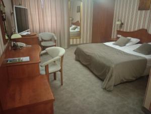 波兹南Biały Dom Henlex Hotel Restauracja的酒店客房,配有一张床、一张桌子和椅子