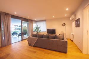 雅典Voula Luxury Apartment的客厅配有大沙发和电视
