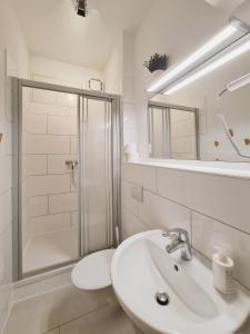 爱尔福特Suite am Park的白色的浴室设有水槽和淋浴。