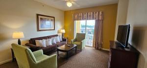 奥兰多Best Disney Resort Condo Orlando的客厅配有沙发、椅子和电视