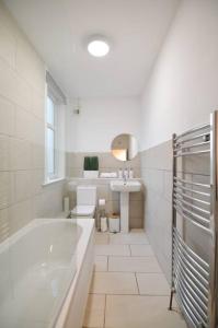法夫Contemporary 3 Bedroom Flat的白色的浴室设有浴缸和水槽。