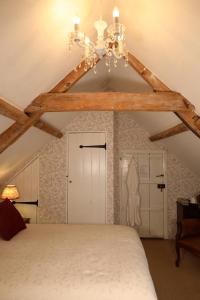 Swanton MorleyCarrick's at Castle Farm的一间卧室配有一张带吊灯的大床