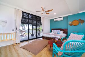 瓜拉丁加奴Villapadu Bayu的卧室拥有蓝色的墙壁,配有一张床和椅子