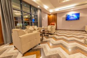 吉达Laten Suites Al Salim Plaza的大堂配有沙发和墙上的电视