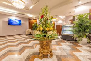 吉达Laten Suites Al Salim Plaza的大堂设有花卉玻璃桌