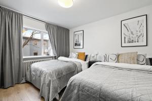 雷克雅未克Venture Vacation - Cozy and Central Apartment的一间卧室设有两张床和窗户。