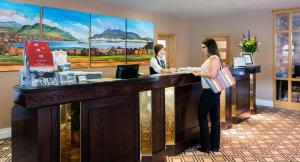 基拉尼Castlerosse Park Resort的站在酒店大堂柜台的女人