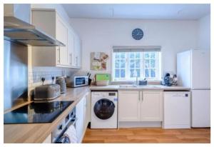 KirmingtonCroxton House的厨房配有白色橱柜和白色家电