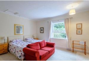 KirmingtonCroxton House的一间卧室配有一张床、一张红色椅子和一个窗户