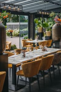 沃登贝赫希梅尔酒店的餐厅里一张长桌,配有椅子和酒杯
