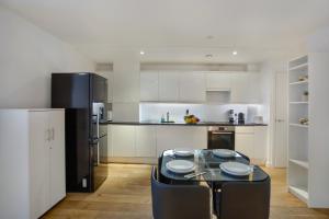 克罗伊登Lovely Spacious Central Croydon Apartment的厨房配有桌子和黑冰箱。