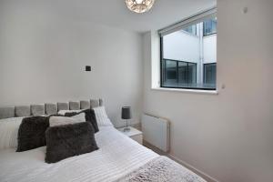 克罗伊登Lovely Spacious Central Croydon Apartment的白色的卧室设有床和窗户