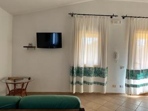 AnnunziataHotel I Menhirs的客厅配有沙发和墙上的电视