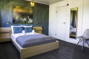 利勒哈默尔利乐哈姆旅行者经济型酒店的卧室配有一张床,墙上挂有绘画作品