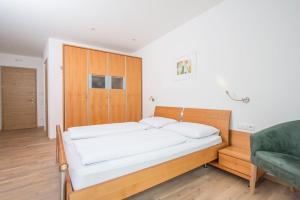布鲁尼科艾德尔维斯公寓的一间卧室配有一张床和一张绿色沙发