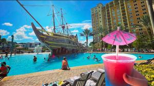 奥兰多Best Disney Resort Condo Orlando的和海盗船在游泳池里喝一杯的人