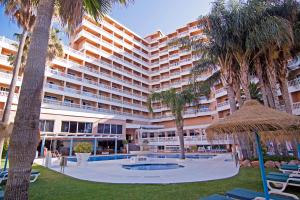 多列毛利诺斯Hotel Parasol by Dorobe的一座带游泳池和棕榈树的大型建筑