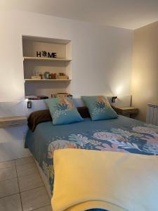 MontmeyanLe Refuge的一间卧室配有一张带蓝色枕头的床