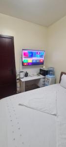 内罗毕JVcribstudios-Ndemi gardens apartments的一间卧室配有一张床和一张带电脑显示器的书桌