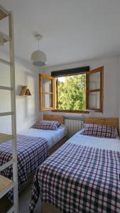 塞尔勒Casa Calpurnia Cerler的一间卧室设有两张床和窗户。