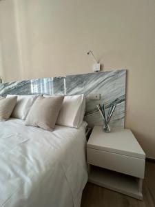 卡拉拉Breccia Nel Mare的卧室配有白色的床和床头柜